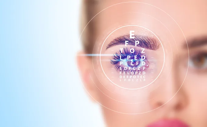 A patient’s eye with a vision chart and laser guide overlaid